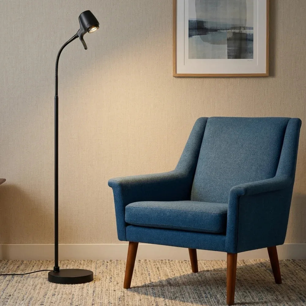 An HD Pro Floor Light in Black beside a blue armchair