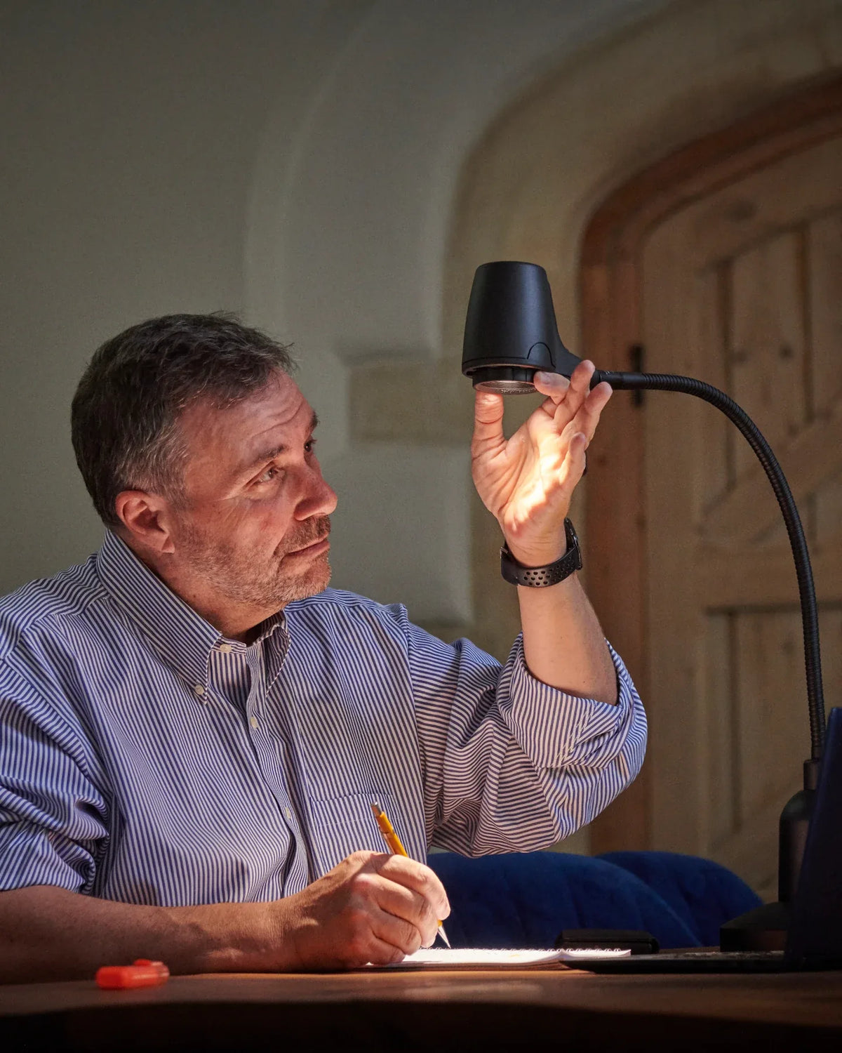 Alex Pratt, founder of Serious Readers, adjusting the head of a Serious Light at his desk
