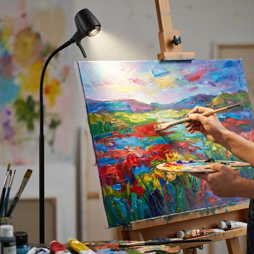 A painter working on the detail of a landscape under a Serious light