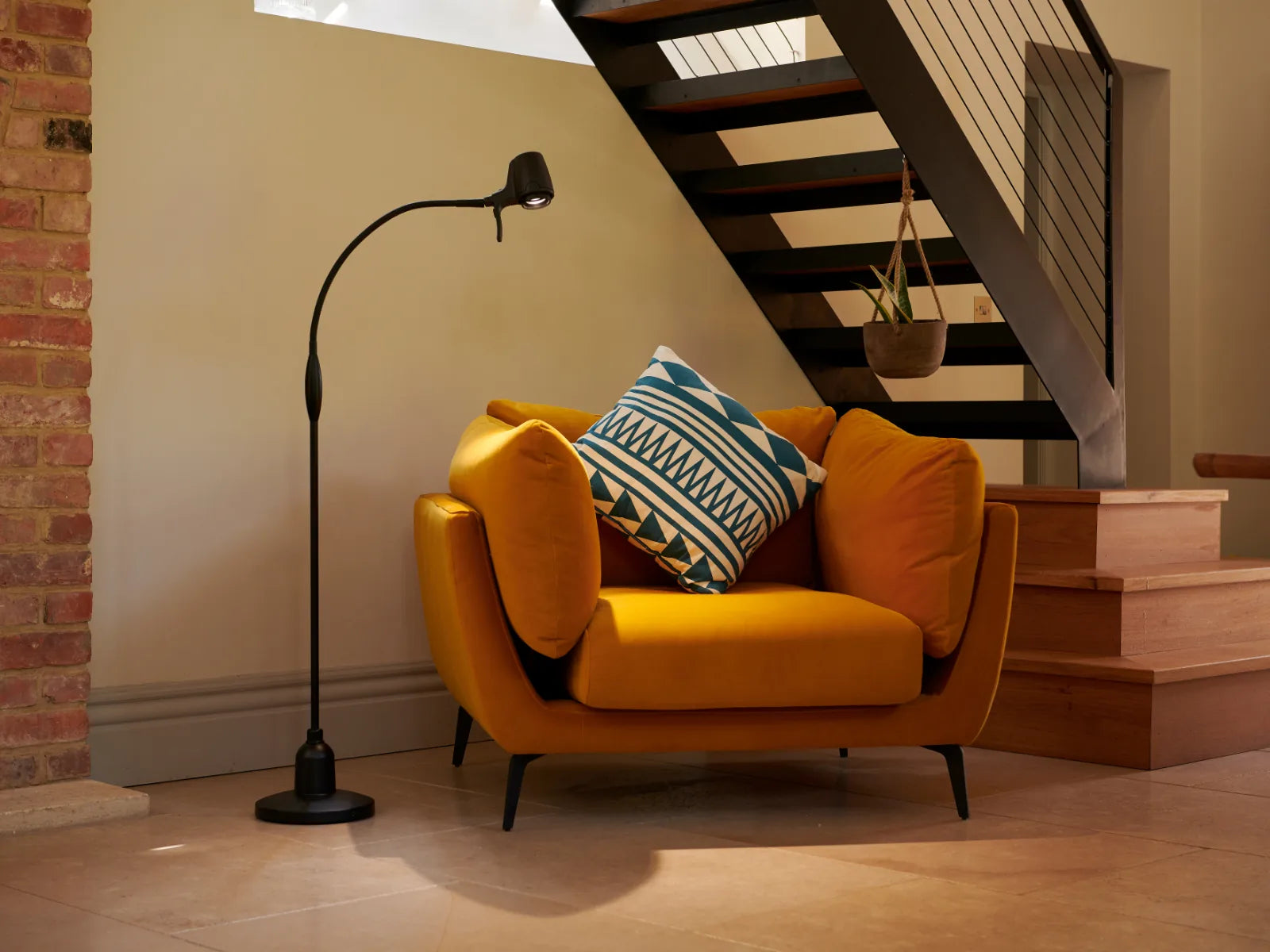 A Serious Floor Light beside a mustard armchair at the foot of the stairs
