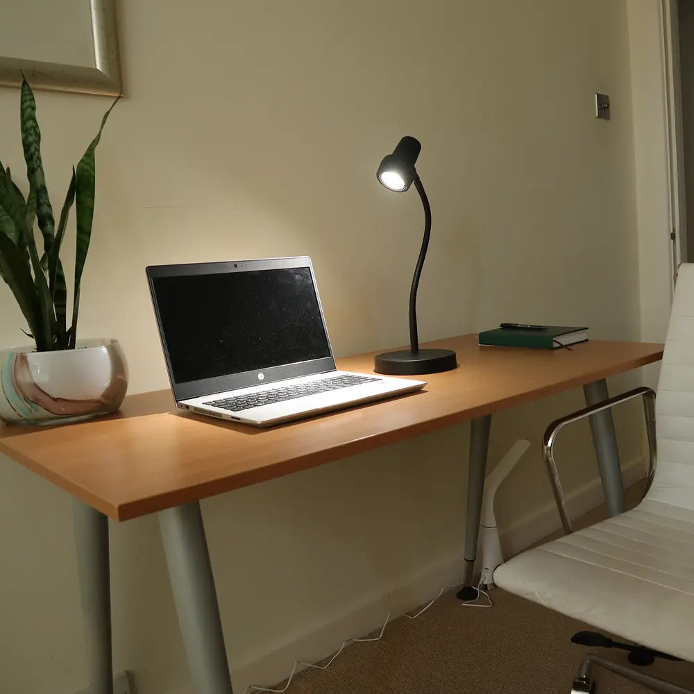 The HD Mini in Black on a desk beside a laptop